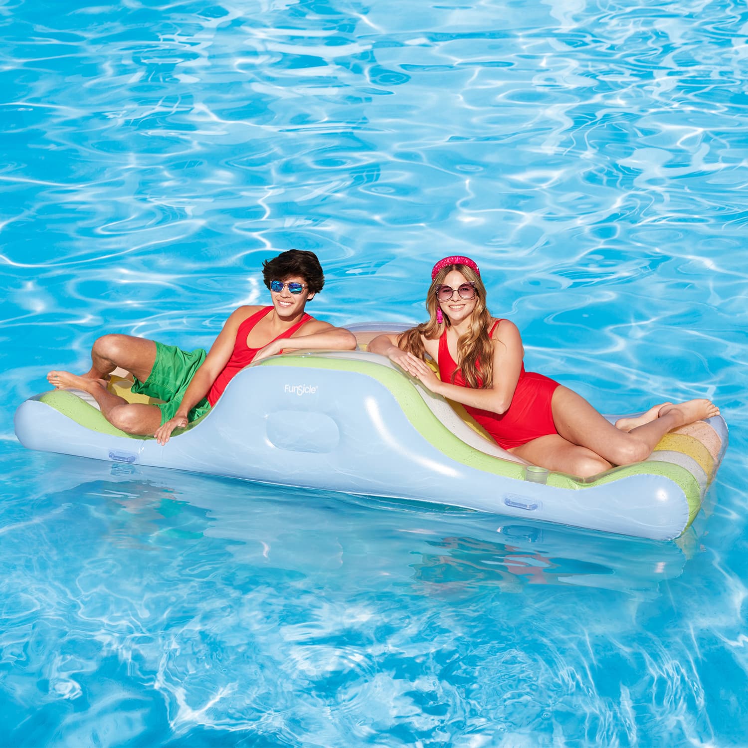 models lounging on Funsicle PIllow Talk Lounge in a pool
