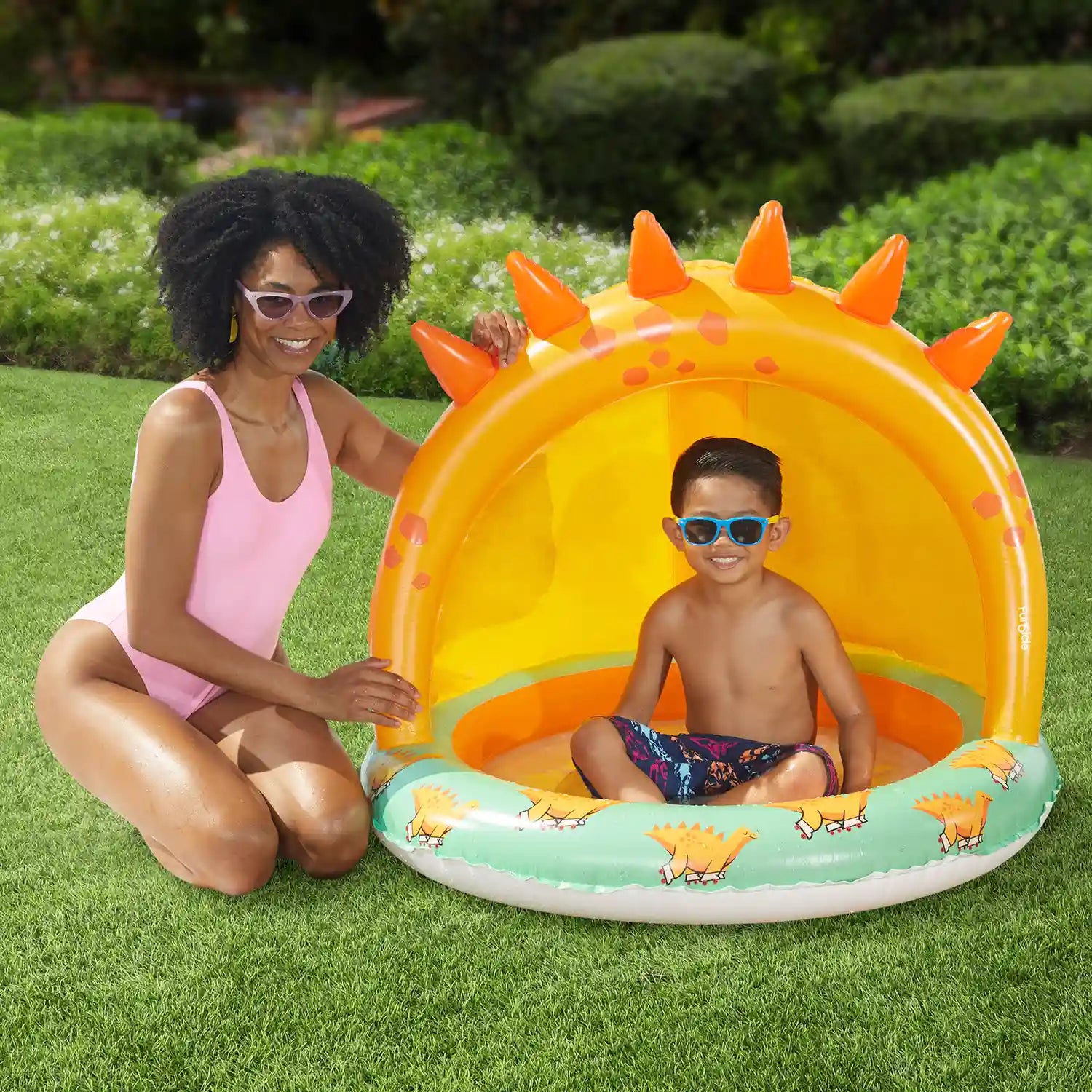 Two people with Funsicle Jurassic Paradise Shaded Pool on a grass background