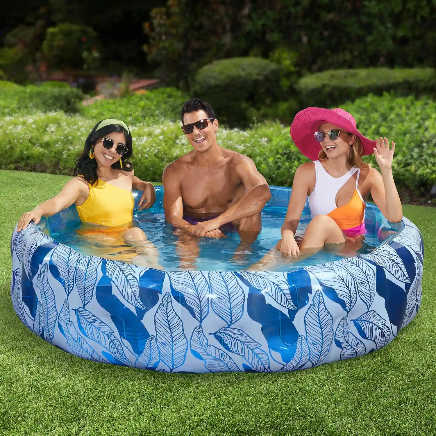 3 people inside Funsicle Sapphire Tropics Funcuzzi Pool on grass field
