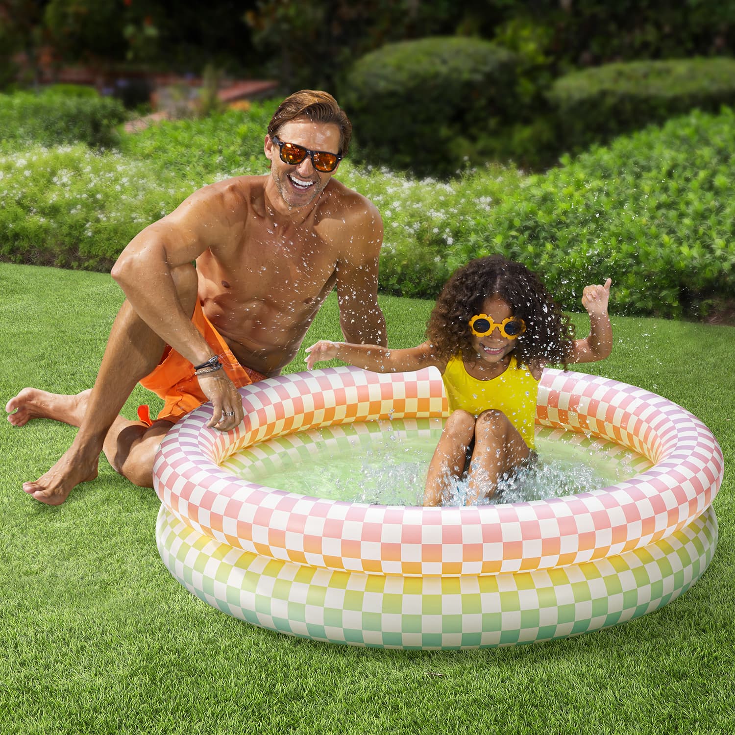 Funsicle Rainbow Checkered Pool with people on grass background