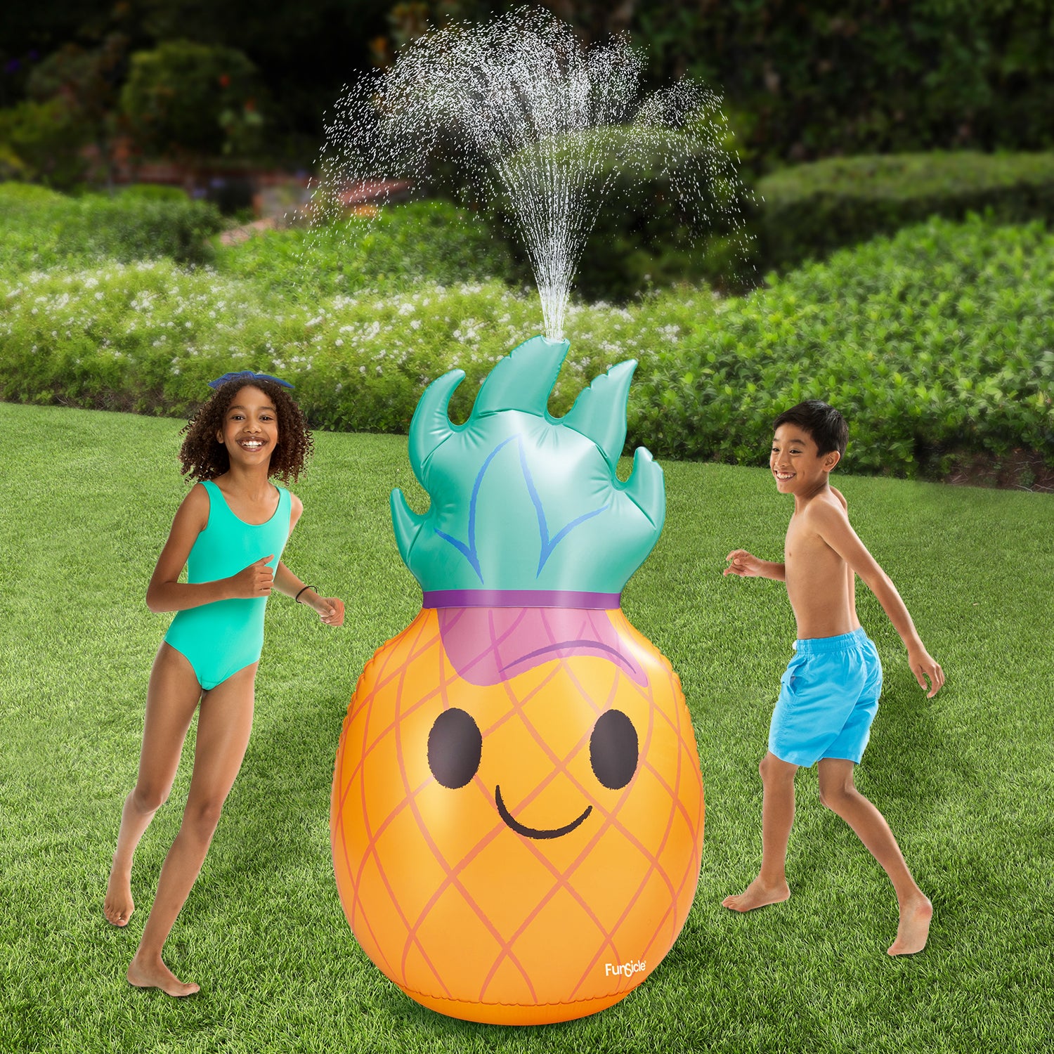 Funsicle Groovy Pineapple Sprinkler with two models around it on a grass background