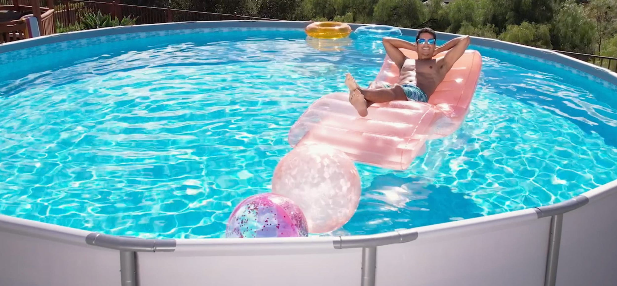 a man lounging on an inflatable lounge in Funsicle above ground pool