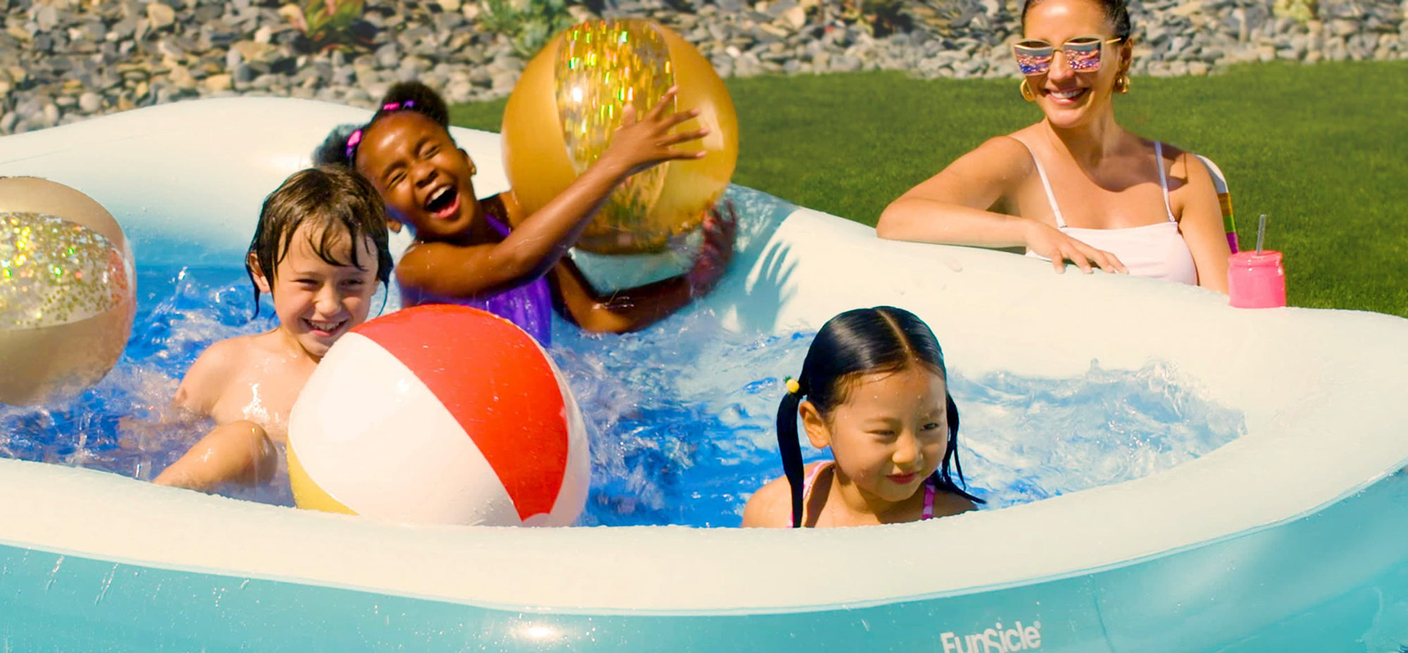 kids swimming in Funsicle inflatable pool with mom next to it