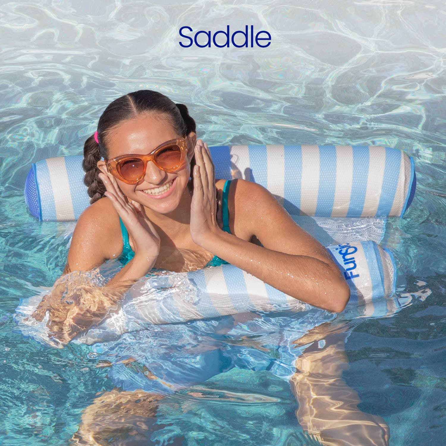 Woman lounging on a striped pool float with 'Saddle' title in clear water.