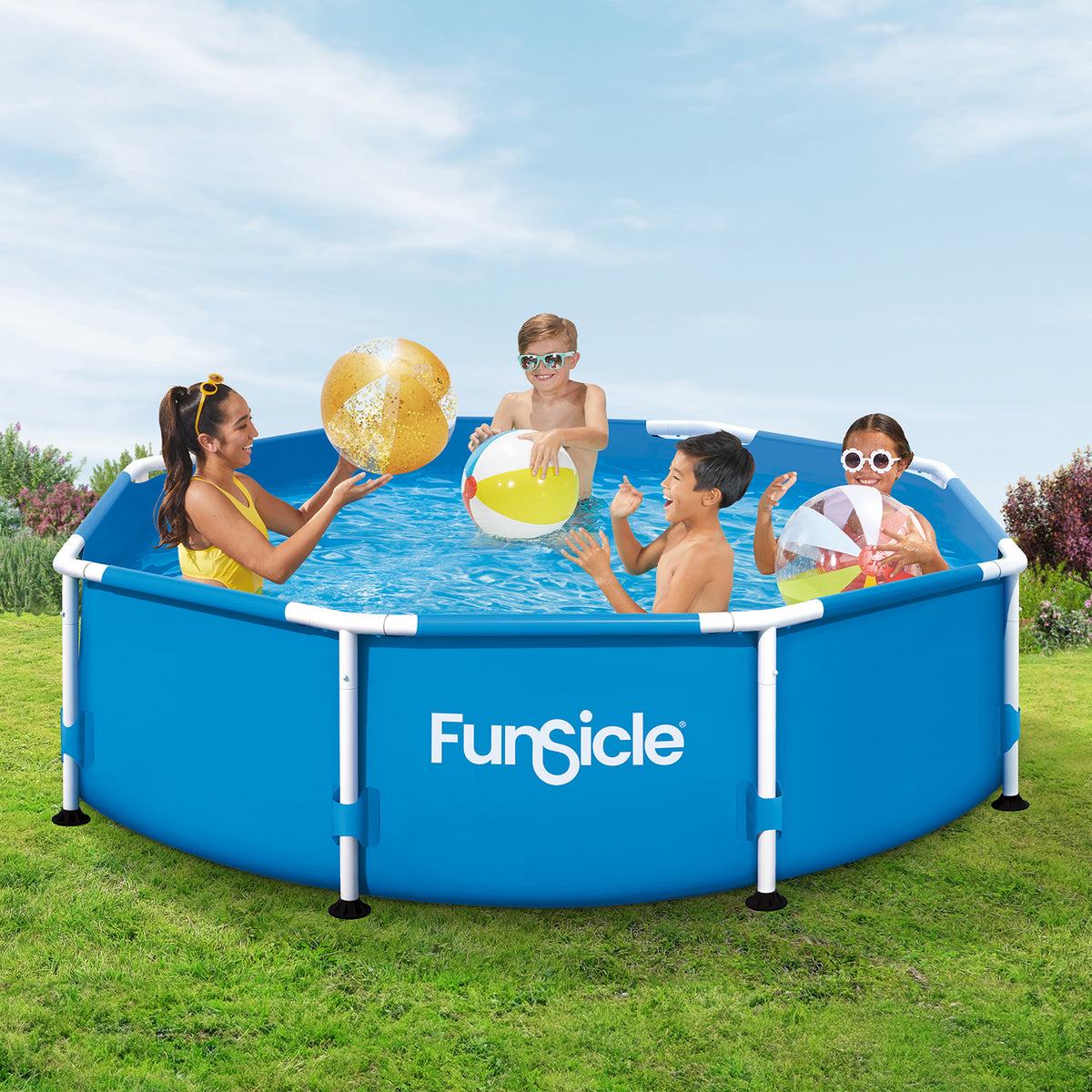 Four people enjoy playing with colorful inflatable beach balls in a blue Funsicle Activity Pool with white frame supports, set on a grassy backyard lawn.