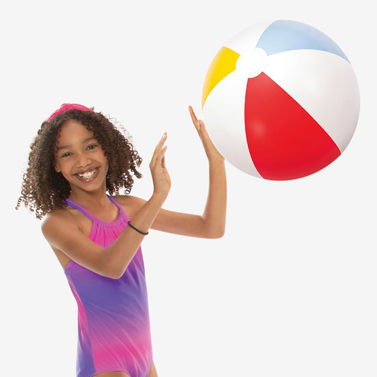 Girl holding a colorful beach ball against a white background