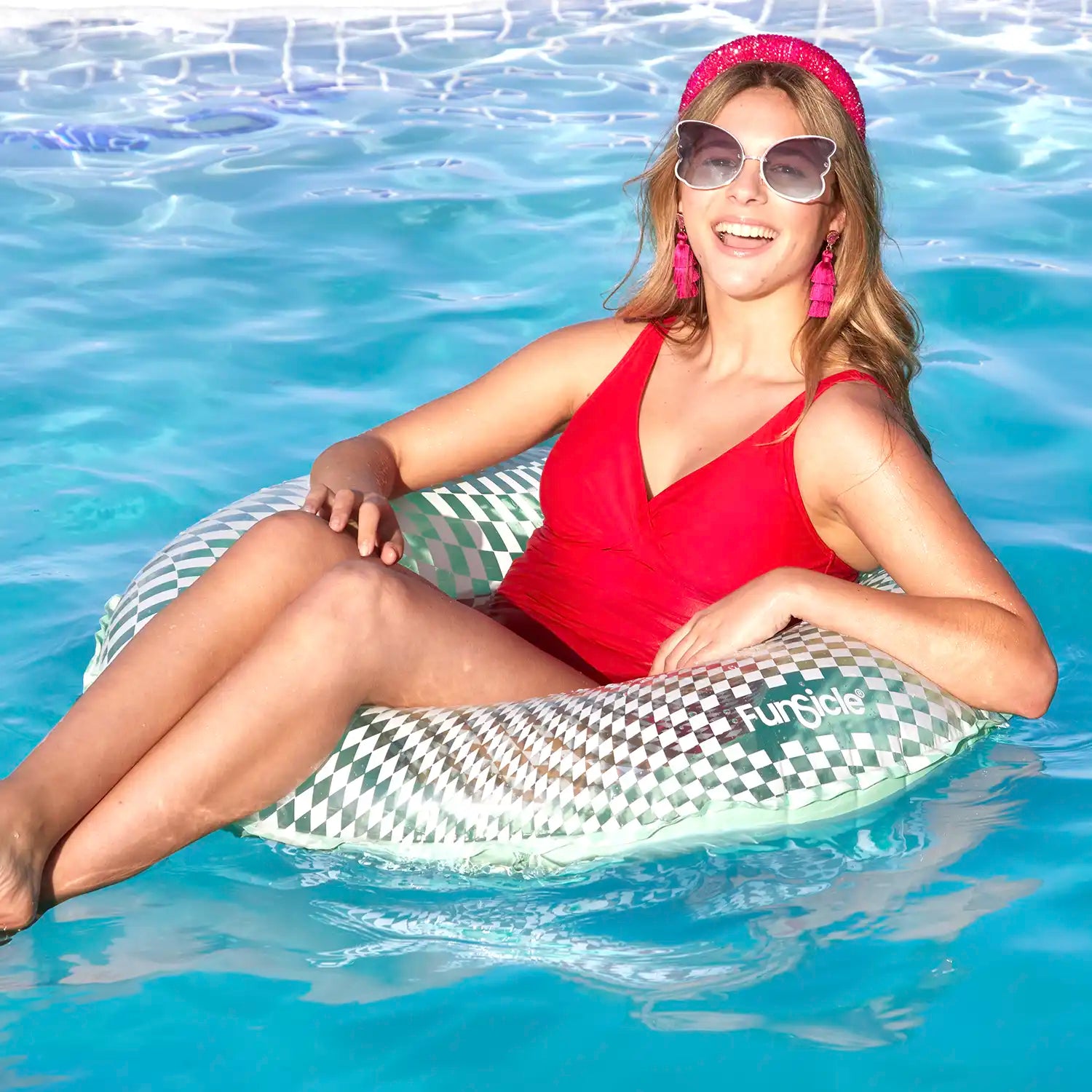 a model lounging on Funsicle Checkered FunTube in a pool