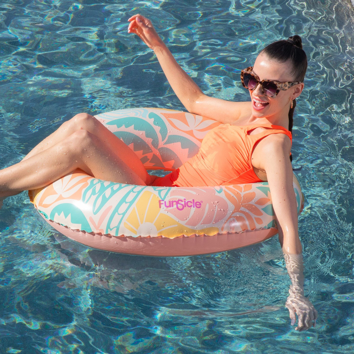Woman relaxing on a floral inflatable ring in a pool