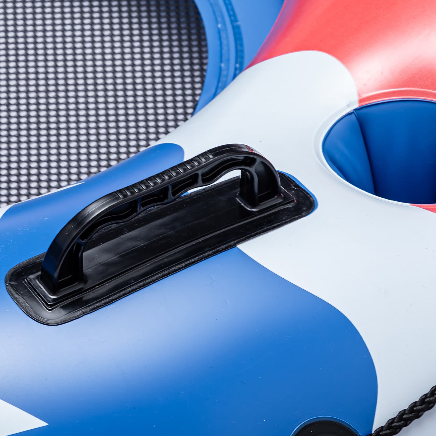 Close-up of a black handle on a blue, white, and red inflatable ring.