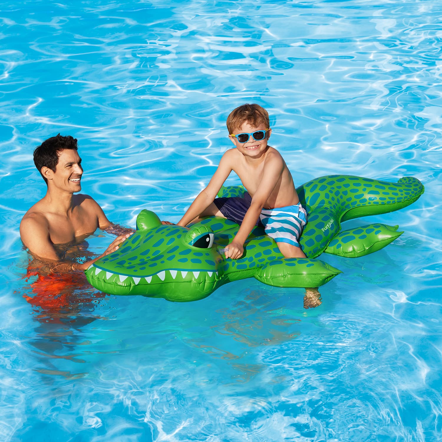 Funsicle Hungry Gator Ride-On with two models around it in a pool