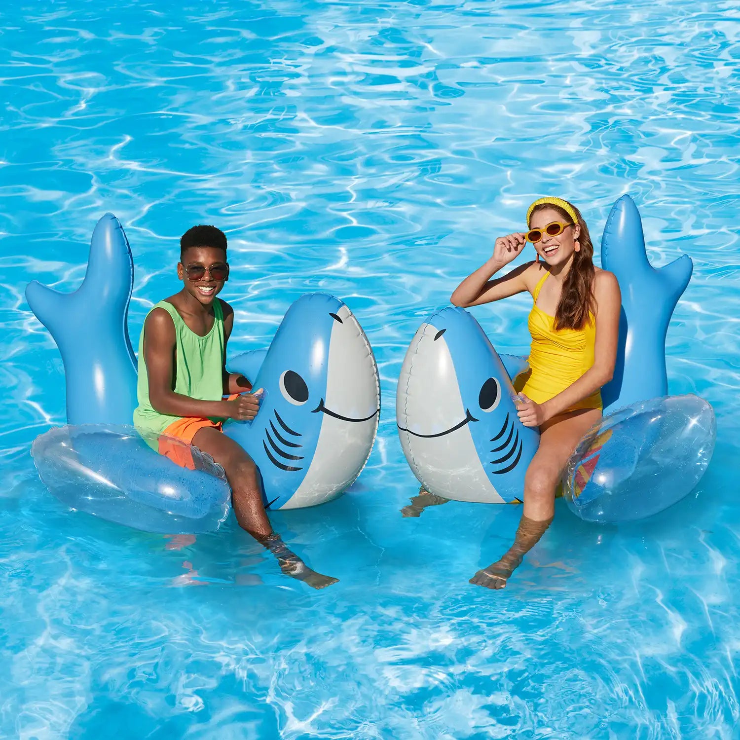 models riding Funsicle Surfin&#39; Shark Pool Play in a pool