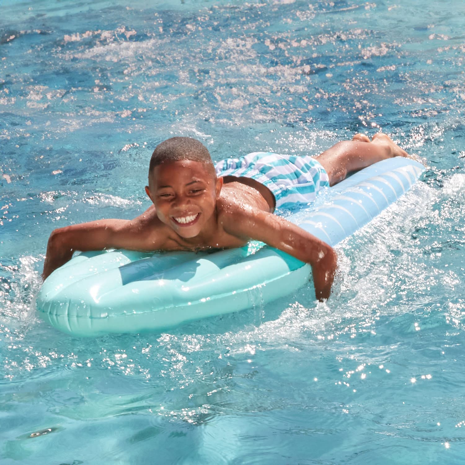 Funsicle California Dreamin&#39; Surfboard Float with a model in a pool