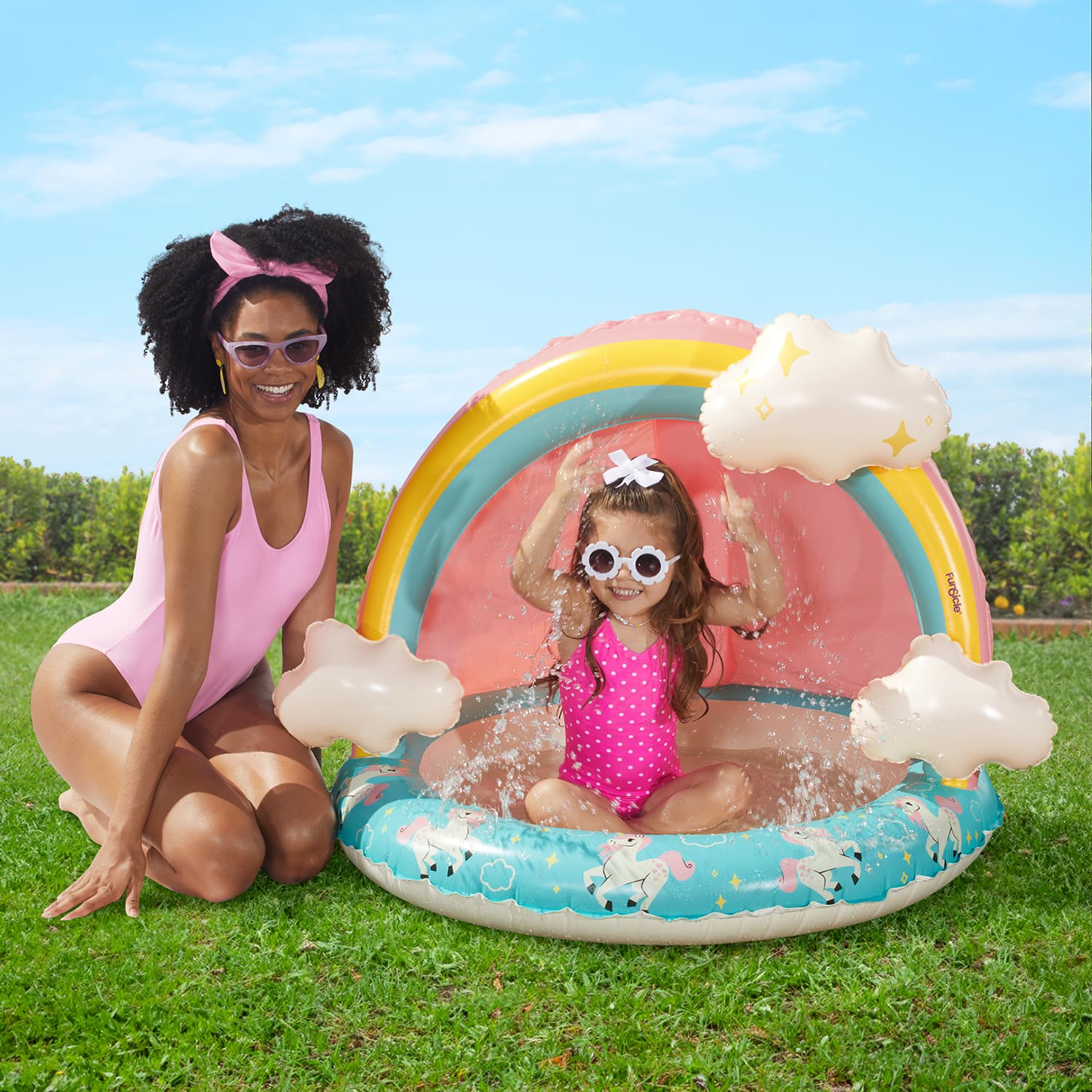 Mother beside a kid underneath Funsicle Rainbow Magic Shaded Pool on grass background