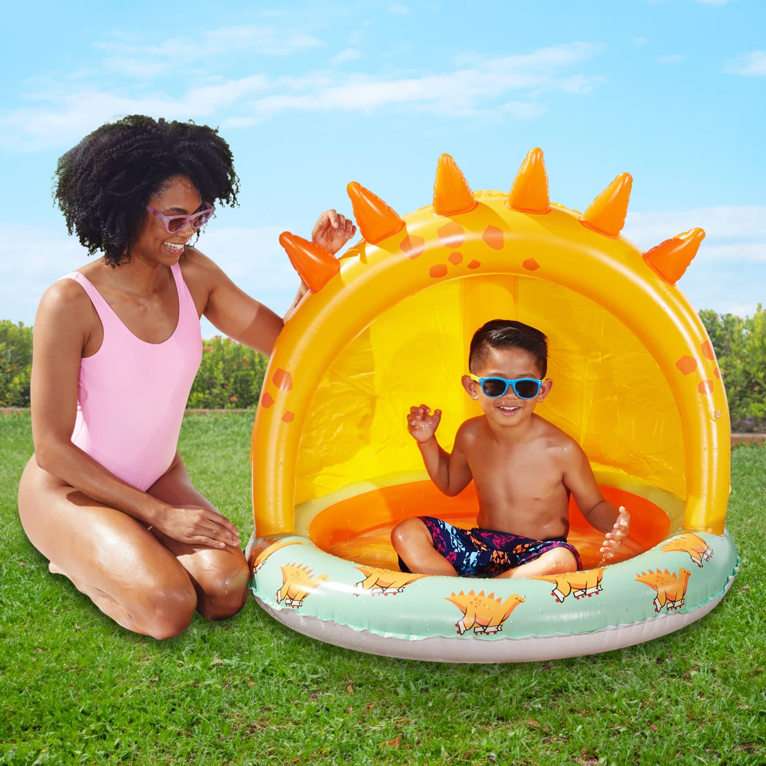 Two people with Funsicle Jurassic Paradise Shaded Pool on a grass background