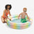a child playing in a colorful inflatable pool with a woman kneeling beside them.