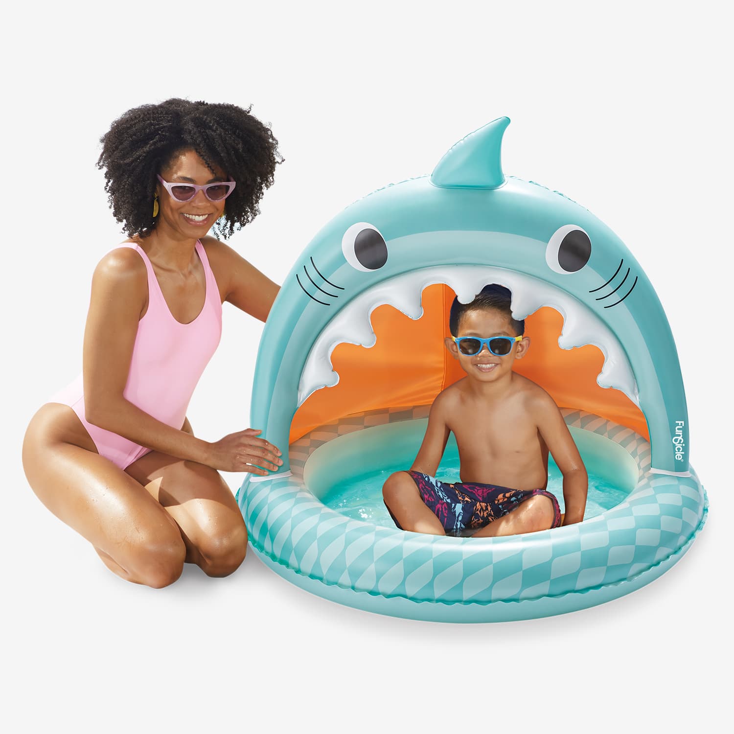 Woman and child playing in a shark-shaped inflatable pool.