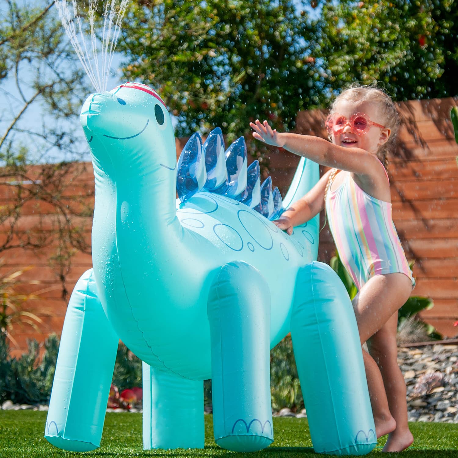 Funsicle Stego Sprinkler with a model at a backyard