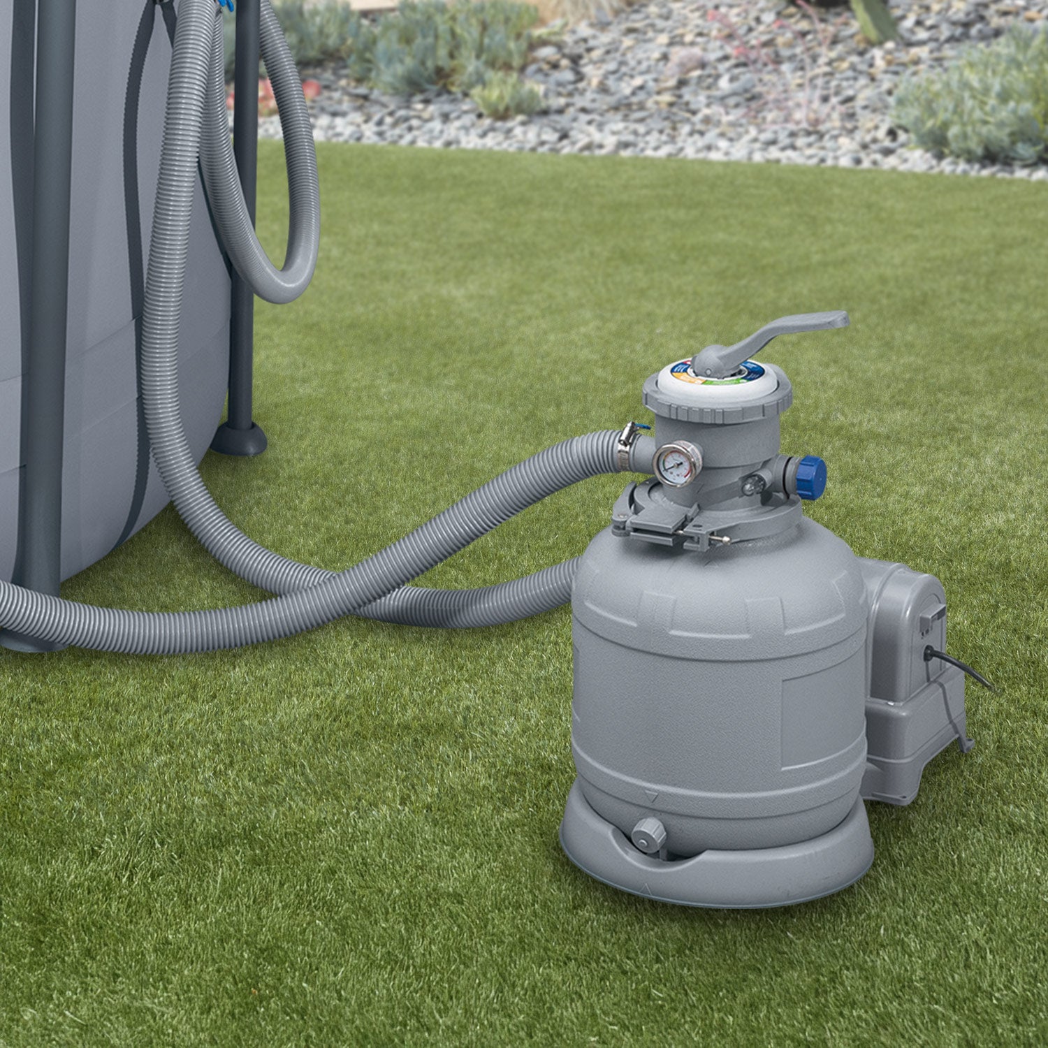 Gray pool pump with hose on grass