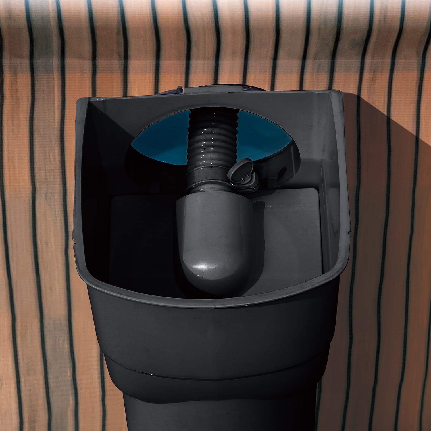 Close up of vacuum adapter for SFX pool pump  a striped brown and black background