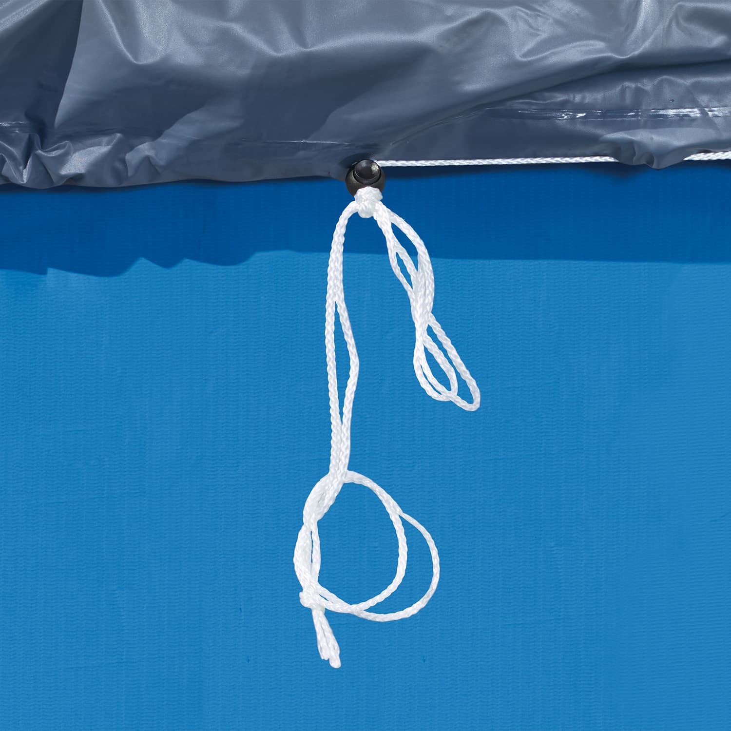 Close-up of gray pool cover with a white rope tied to it