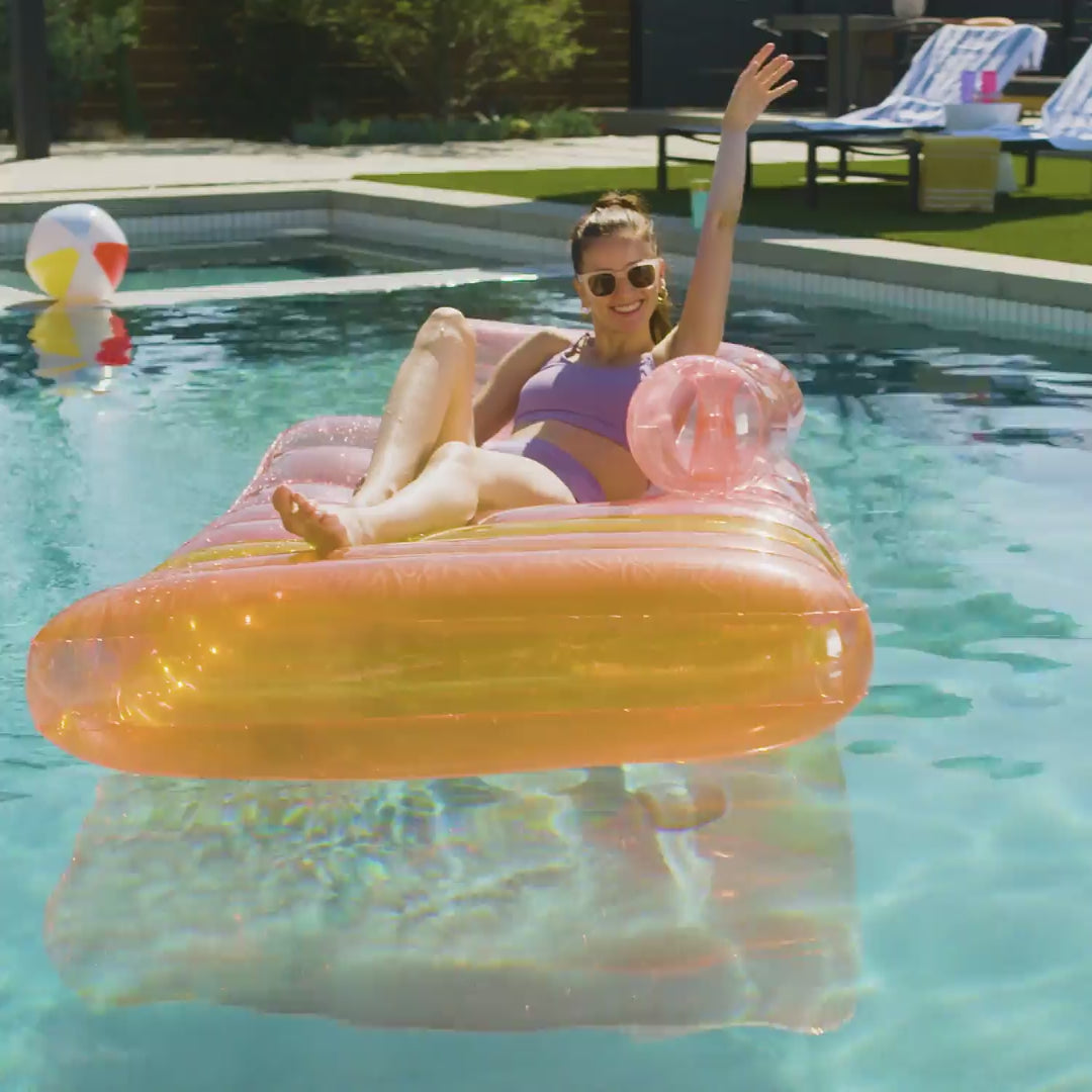 a model lounging on Funsicle Sofa Bed Lounge in a swimming pool